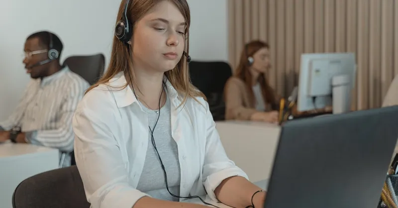 Multiracial call center employees focused on providing customer support with laptops.