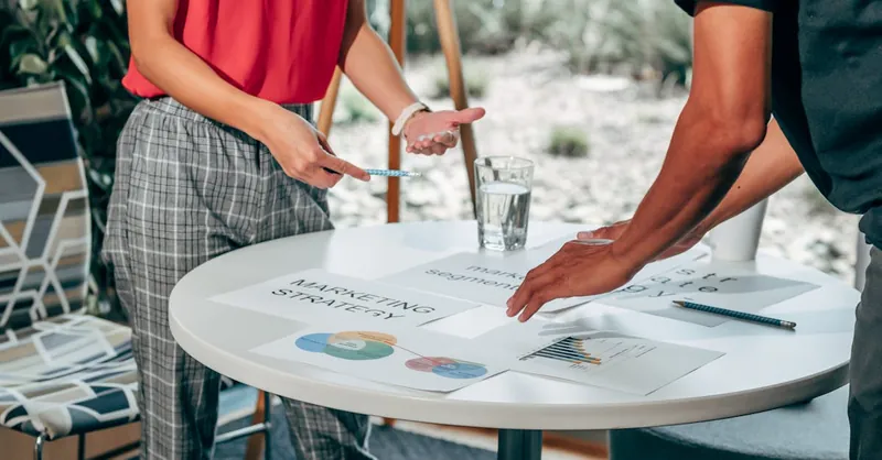 Two colleagues collaborate on marketing strategies at a modern workspace.