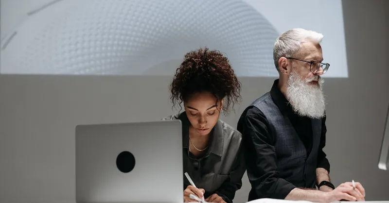 Two designers collaborating on a project with a futuristic model projection, illustrating teamwork and innovation.