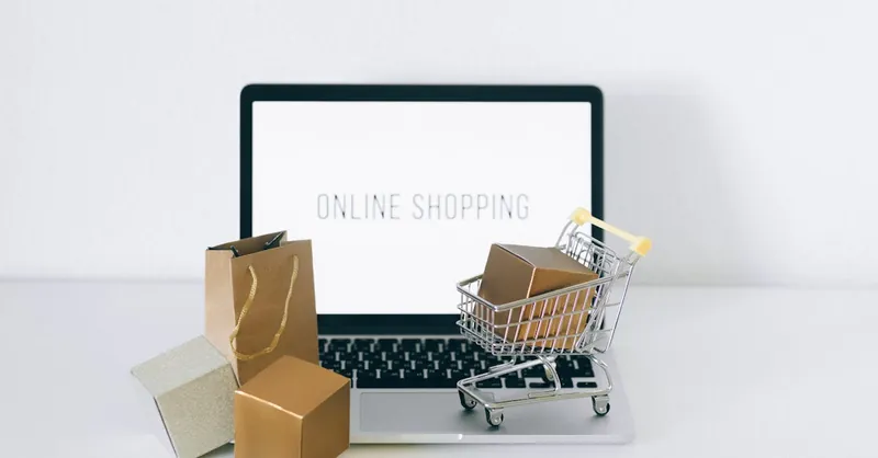 Laptop displaying online shopping with boxes and cart, representing ecommerce.